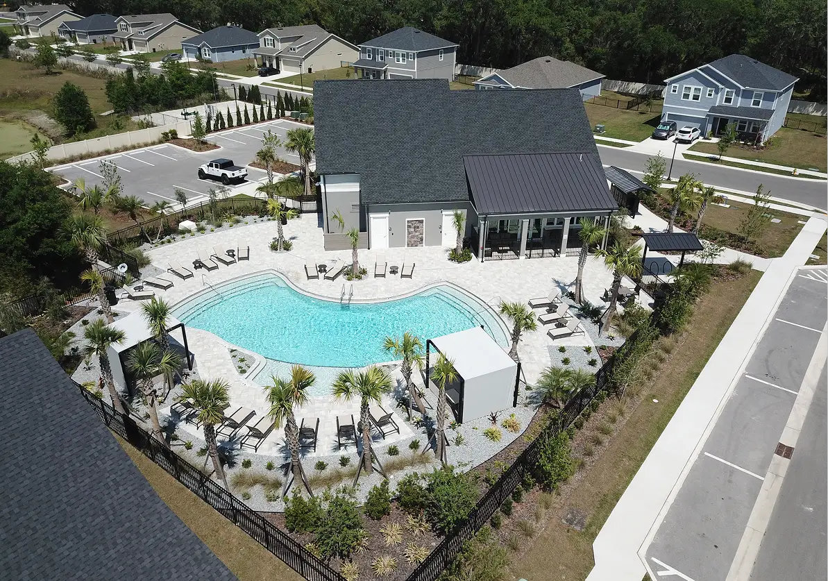 Aerial view of curved swimming pool with lounge chairs, cabana, and palm trees in a luxury residential community in St Petersburg, FL.
