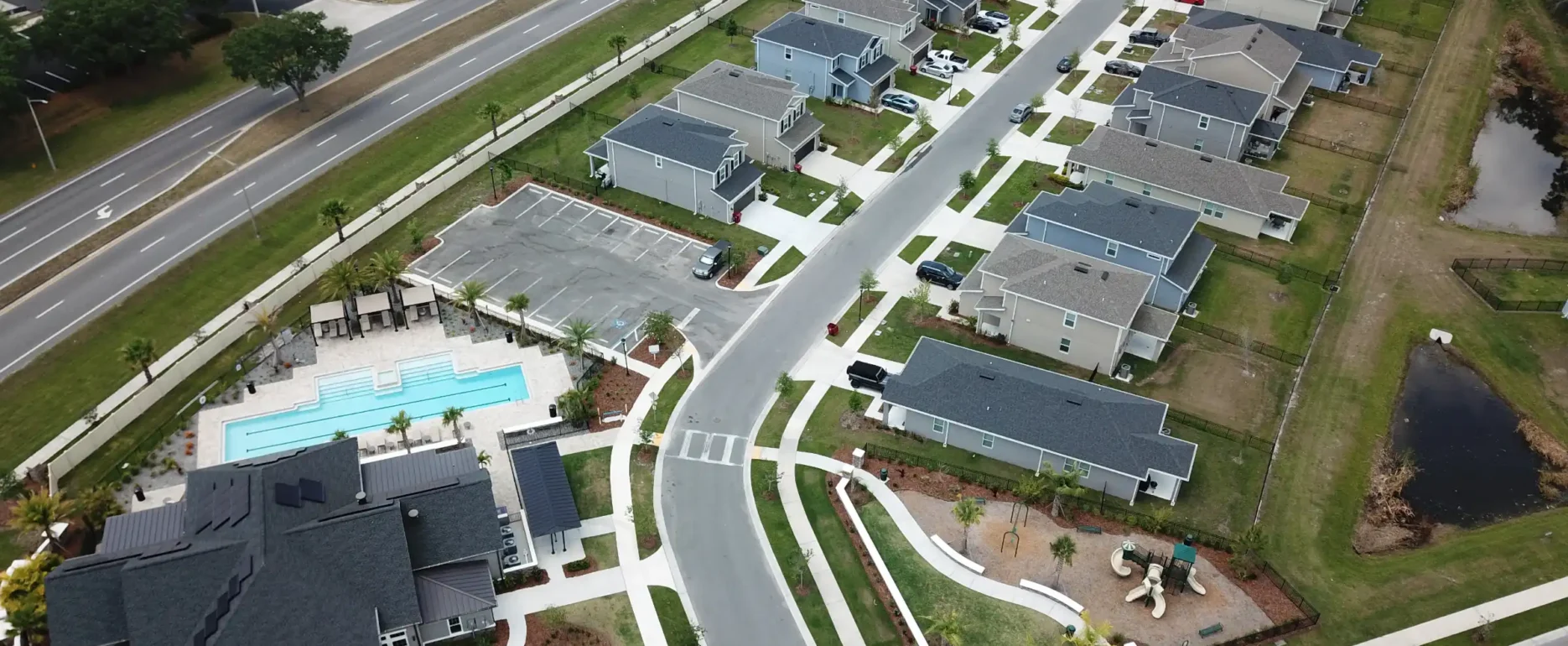 Aerial view of luxury residential community in St Petersburg FL featuring modern homes, community pool, landscape architecture, and manicured grounds.