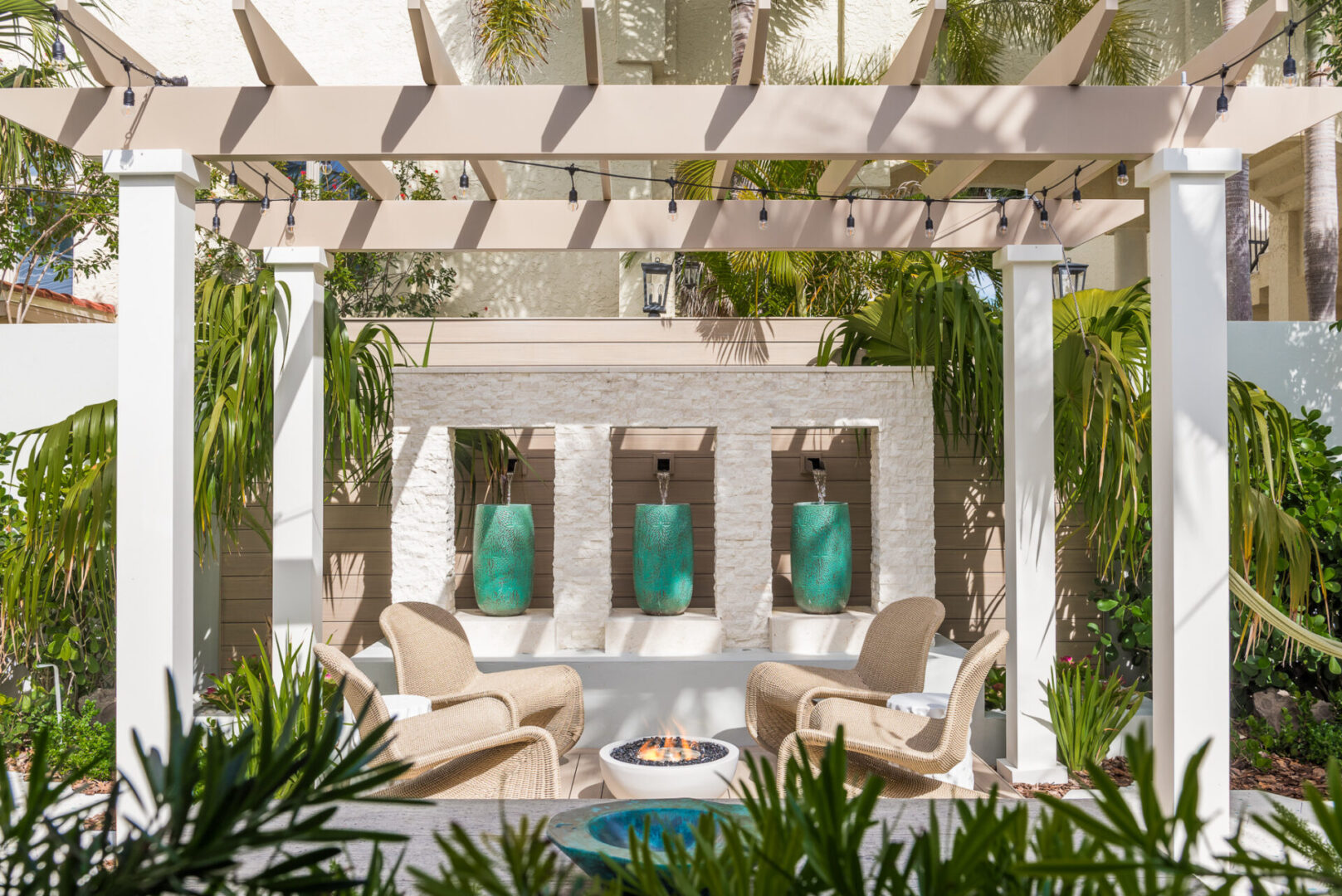 Contemporary outdoor courtyard featuring white pergola, beige lounge chairs, and turquoise ceramic planters under luxury landscape design in St Petersburg.
