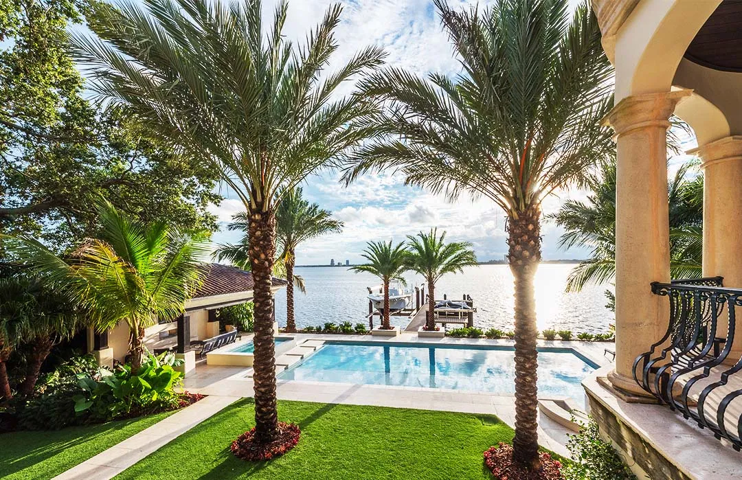 Luxury waterfront pool with palm trees and columns overlooking bay in St Petersburg FL residential community