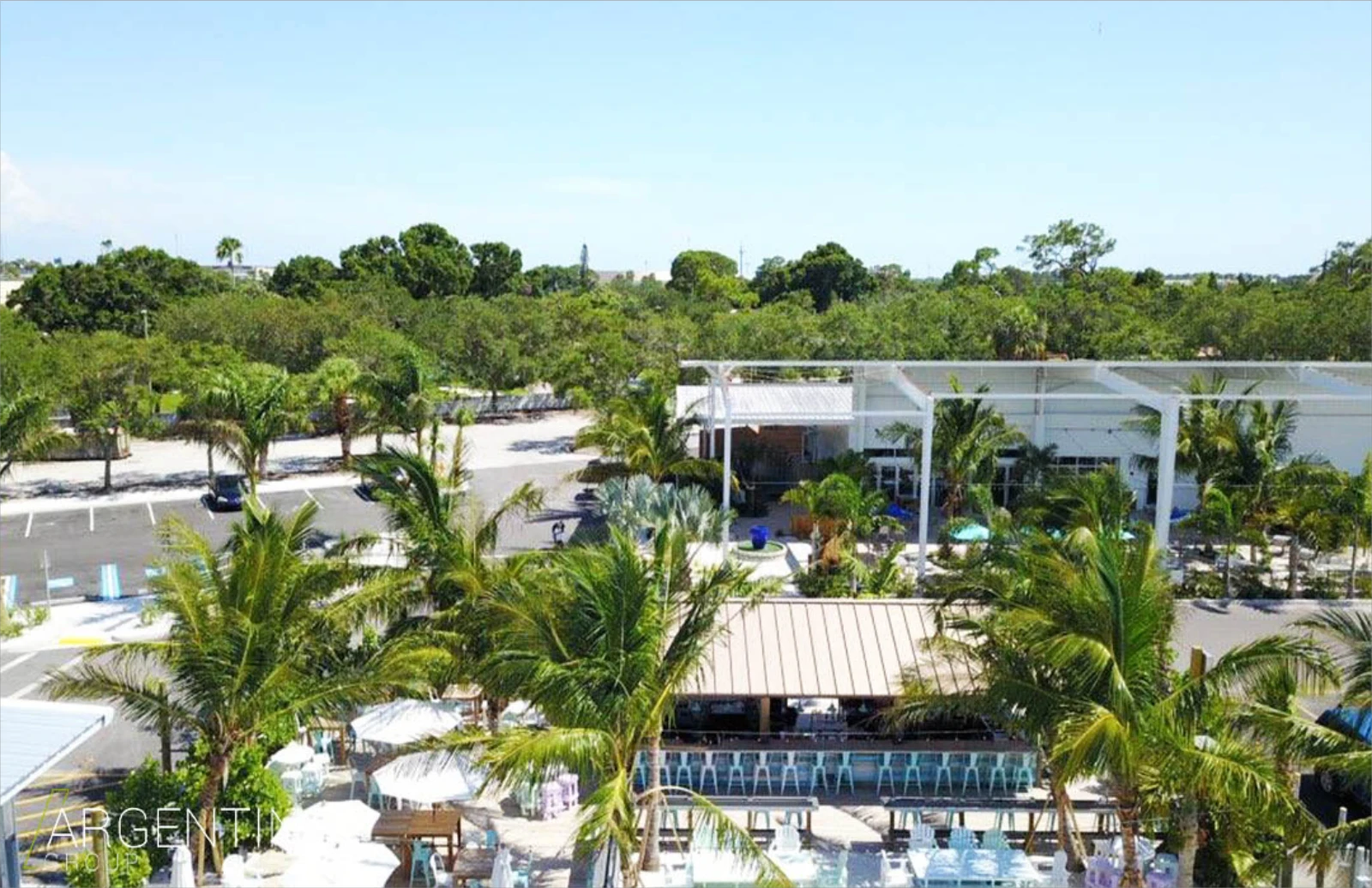 Luxury resort pool area with white umbrellas, palm trees, and modern white pavilion overlooking waterfront in St Petersburg, FL