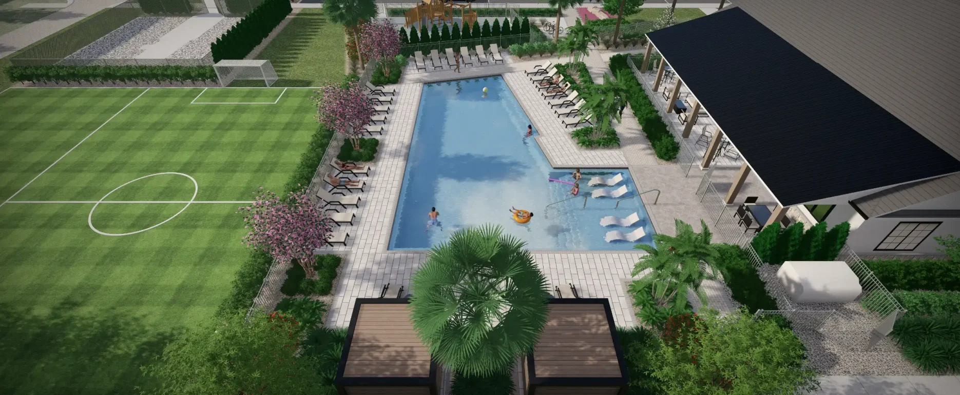 Aerial view of luxury residential community pool with lounge chairs, manicured soccer field, and modern architecture in St Petersburg, FL