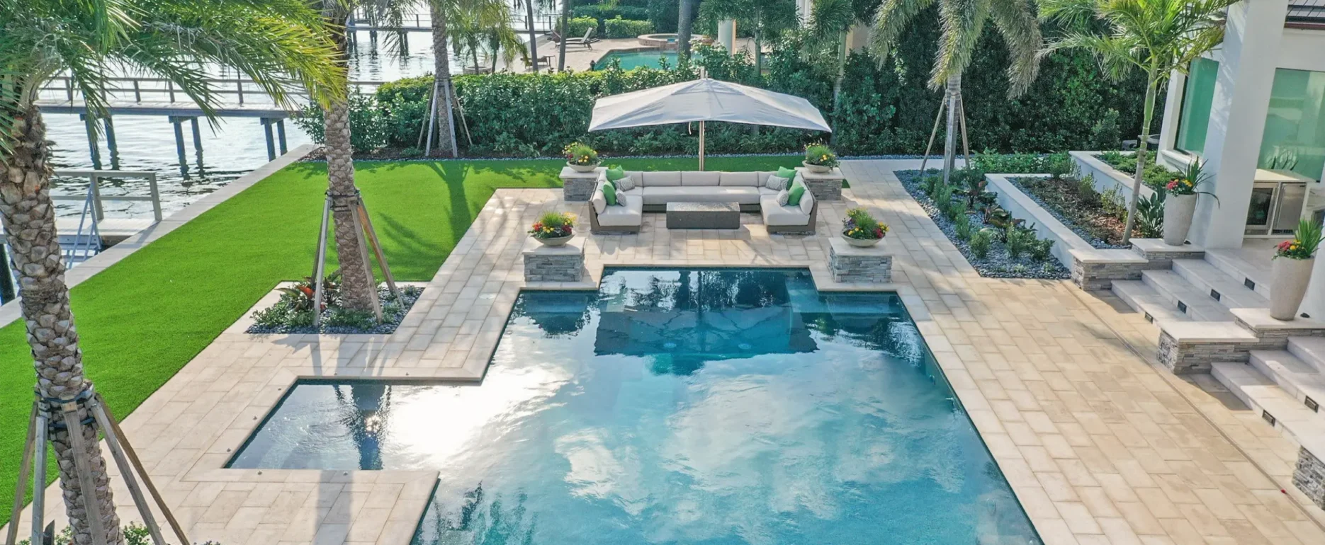 Luxury pool design with stone deck, lounge seating, and waterfront views in St Petersburg, FL residential community.