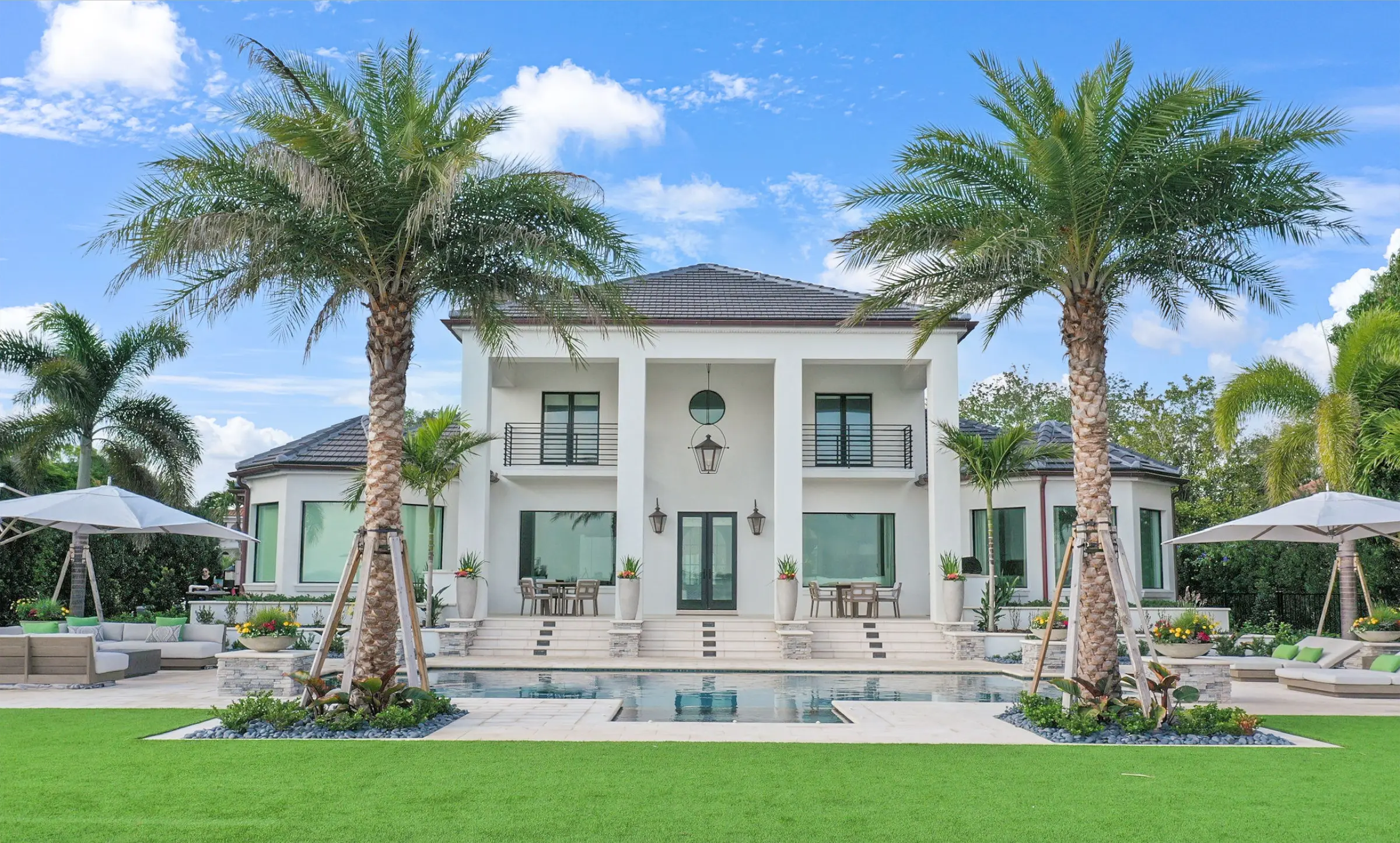 Luxury modern white home with elegant pool, palm trees, and manicured lawn in St Petersburg residential community.