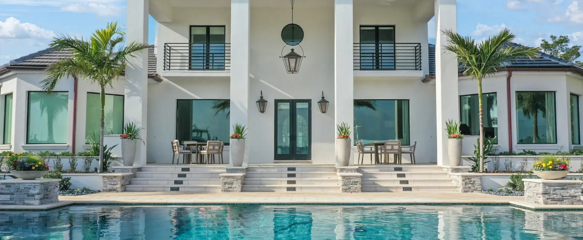 Contemporary white residential home with turquoise pool, dual spa, and expansive deck featuring luxury outdoor construction and landscape design in St Petersburg.