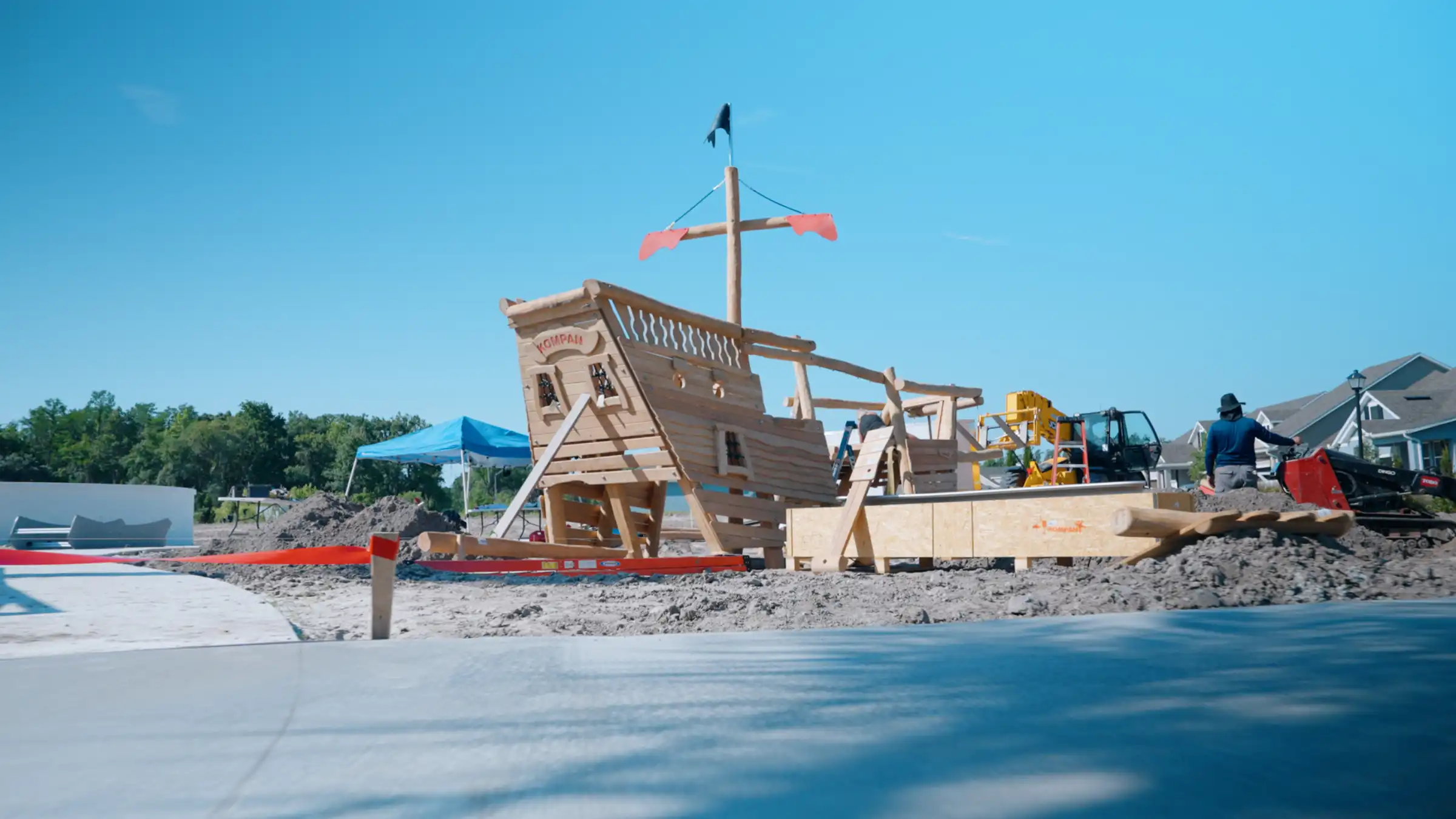 Wooden pirate ship structure with cross on sandy beach, featuring playground equipment and construction in progress in St Petersburg, FL residential community.