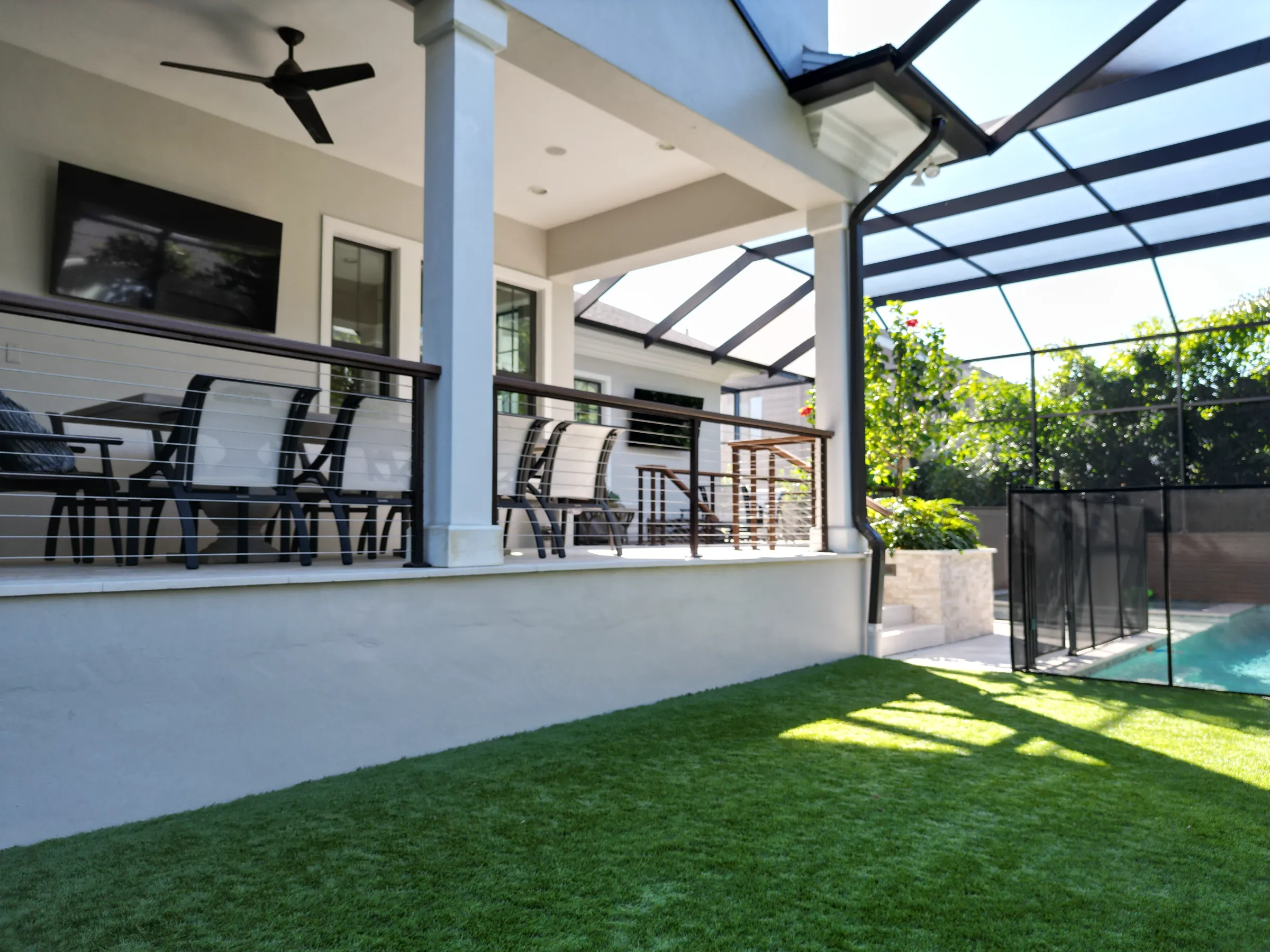 Contemporary St Petersburg home with glass-roofed patio, lounge seating, manicured lawn, and pool area featuring luxury outdoor construction and landscape design.