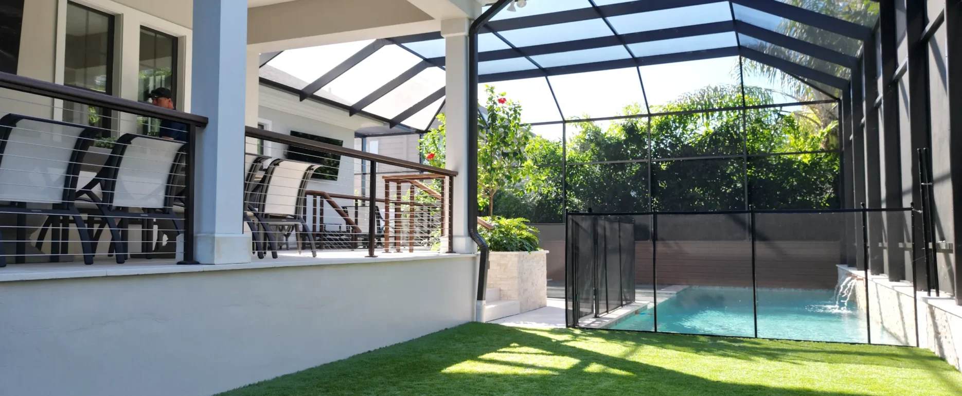 Contemporary St Petersburg home with screened pool, manicured lawn, and modern glass pergola covering patio area.