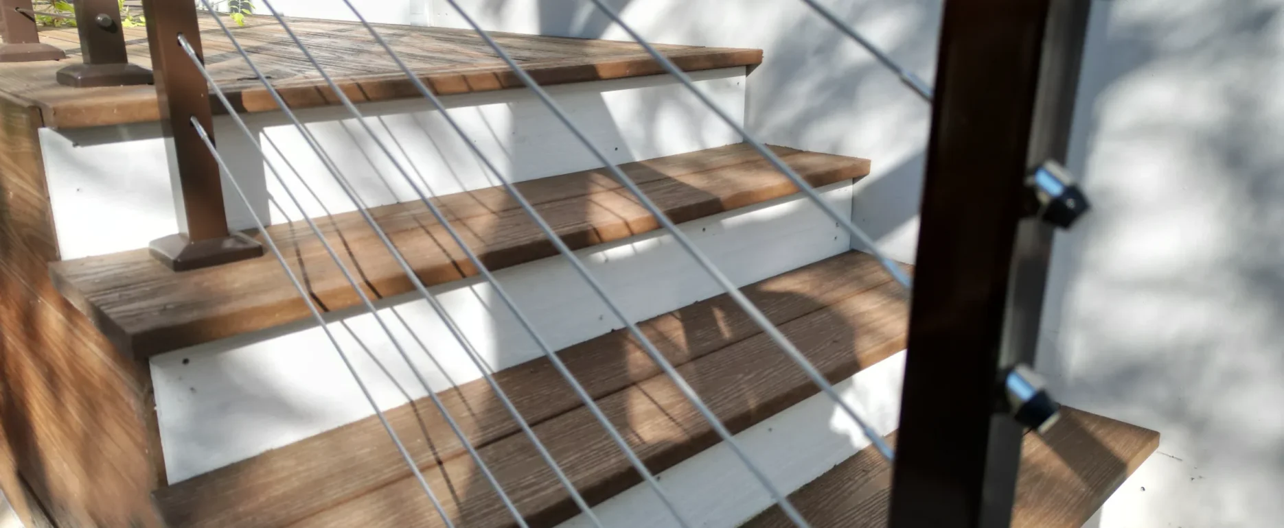 Wooden staircase with metal cable railings and contemporary design in luxury residential construction, St Petersburg FL.
