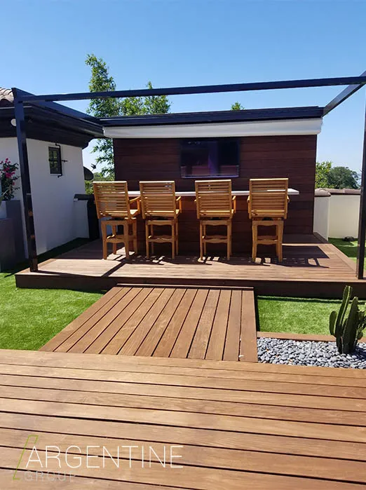 Luxury rooftop entertaining space featuring wooden bar seating, dark pergola, and manicured lawn in St Petersburg residential community.