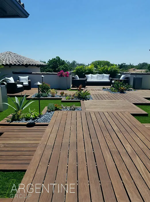Expansive rooftop terrace featuring composite wood decking, lounge seating areas, manicured lawn sections, and lush landscaping overlooking Saint Petersburg waterfront.