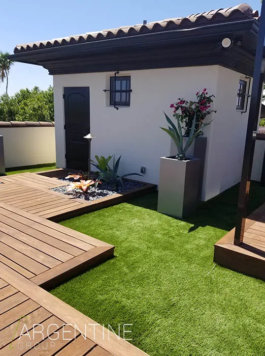 Contemporary white pool cabana with black pergola roof and artificial turf deck area, showcasing luxury residential outdoor design in St Petersburg, FL.