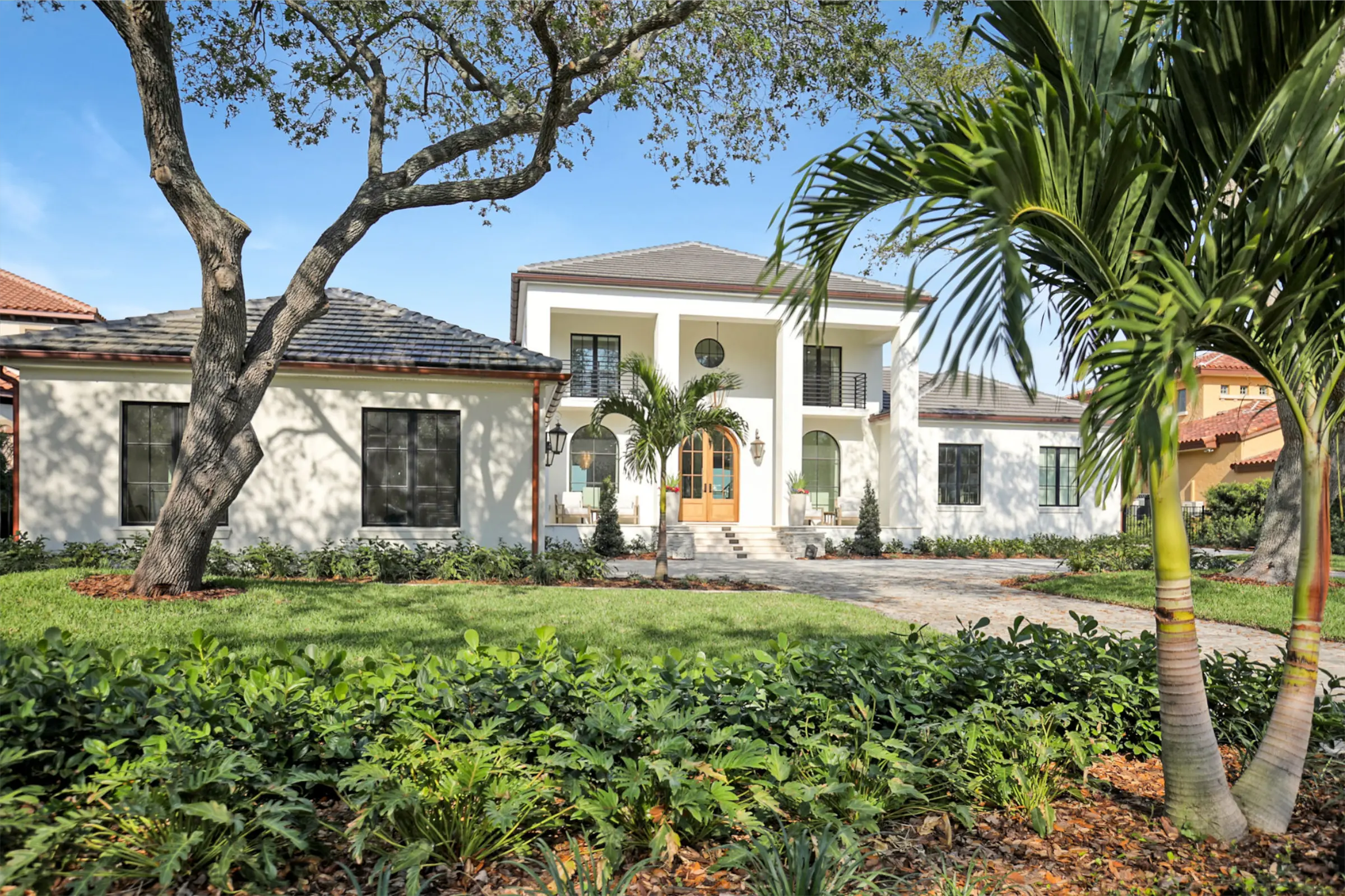 Modern white residential home with manicured lawn, palm trees, and professional landscape architecture in St Petersburg, FL.