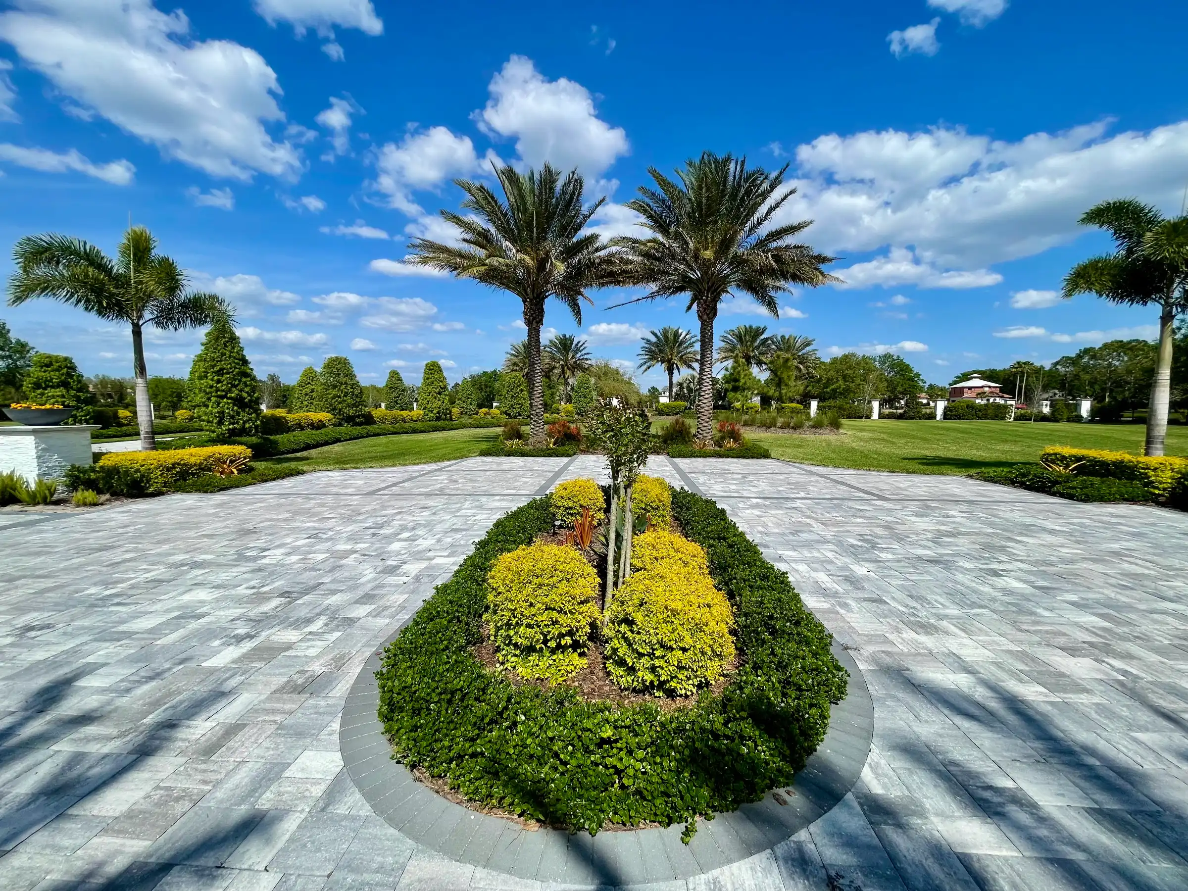 Symmetrical landscape architecture featuring palm trees and manicured gardens with paved walkway in St Petersburg, Florida luxury residential community.